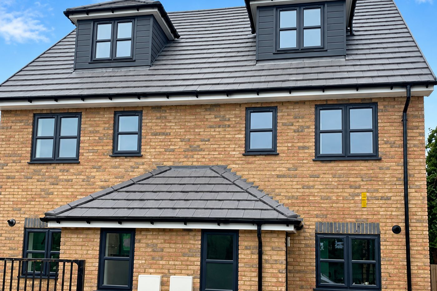 A three storey brick house with dormer windows